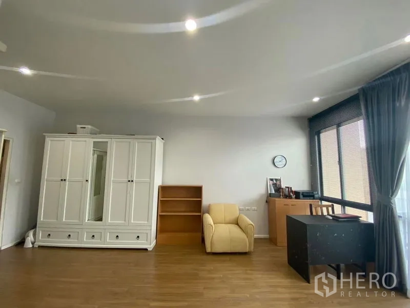 Townhouse for rent or sale in Saphan Sung, Bangkok - Large multipurpose room with white wardrobe, desk, shelves and wide windows.