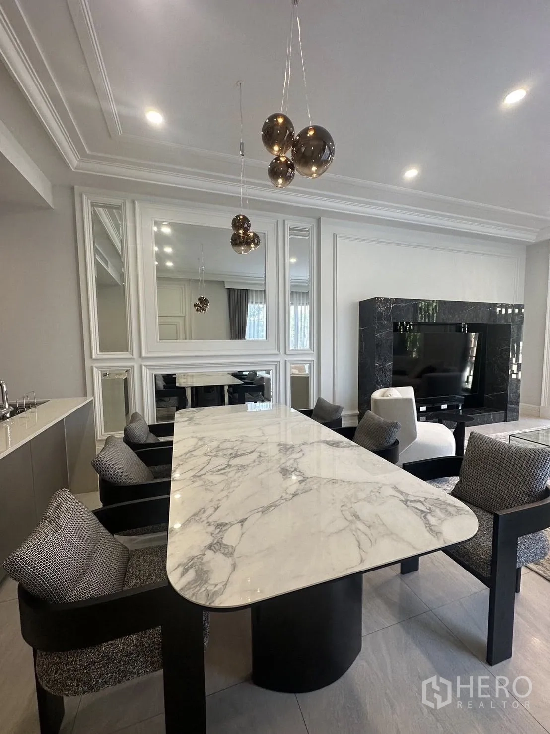 Detached House for rent or sale in Bang Kapi, Bangkok - Dining area with long marble dining table, pendant lights and open pantry.