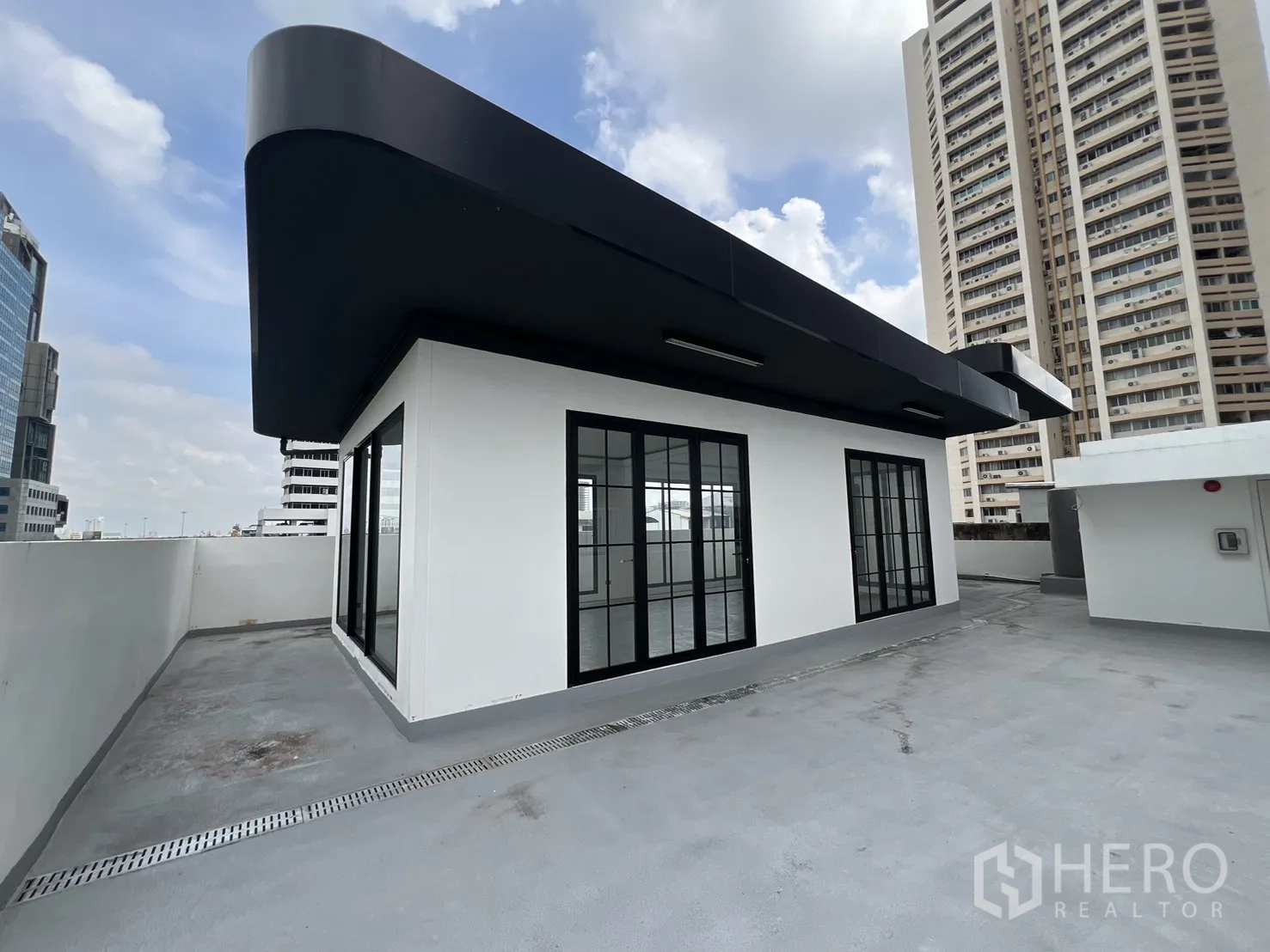 Retail Space for rent in Khlong Toei, Bangkok - Bright open space with linear ceiling lights and tall windows.