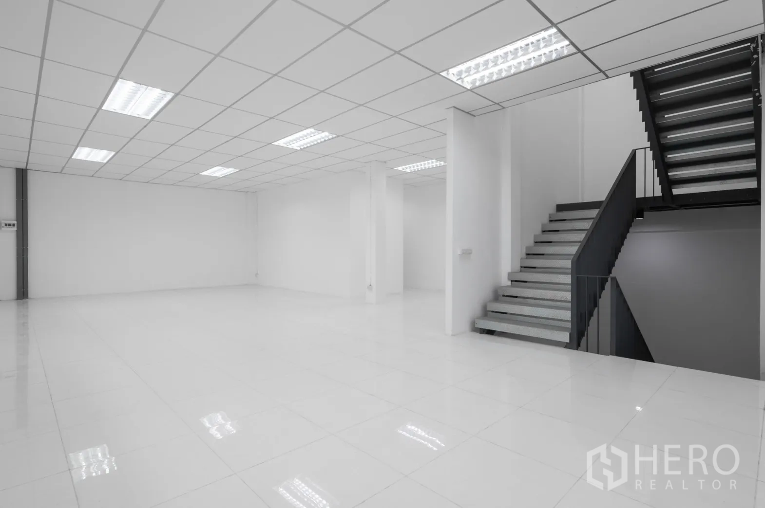 Factory for rent in Pathum Thani - Clean office lobby with tiled flooring and a metal staircase to the upper level.
