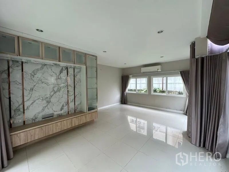 Detached House for sale in Bang Khen, Bangkok - Living area with TV cabinet featuring marble accent and full-height windows.