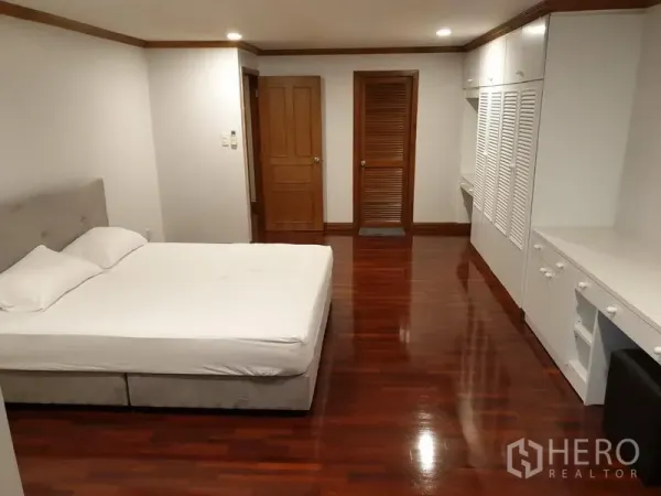 公寓 出租在Watthana, Bangkok - 大卧室，双人床、白色内置衣柜、书桌与抛光木地板。