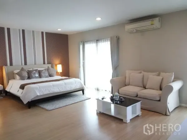 公寓 出租或出售在Pathum Wan, Bangkok - 宽敞主卧，特大床、沙发休闲区与茶几，落地门通向阳台。