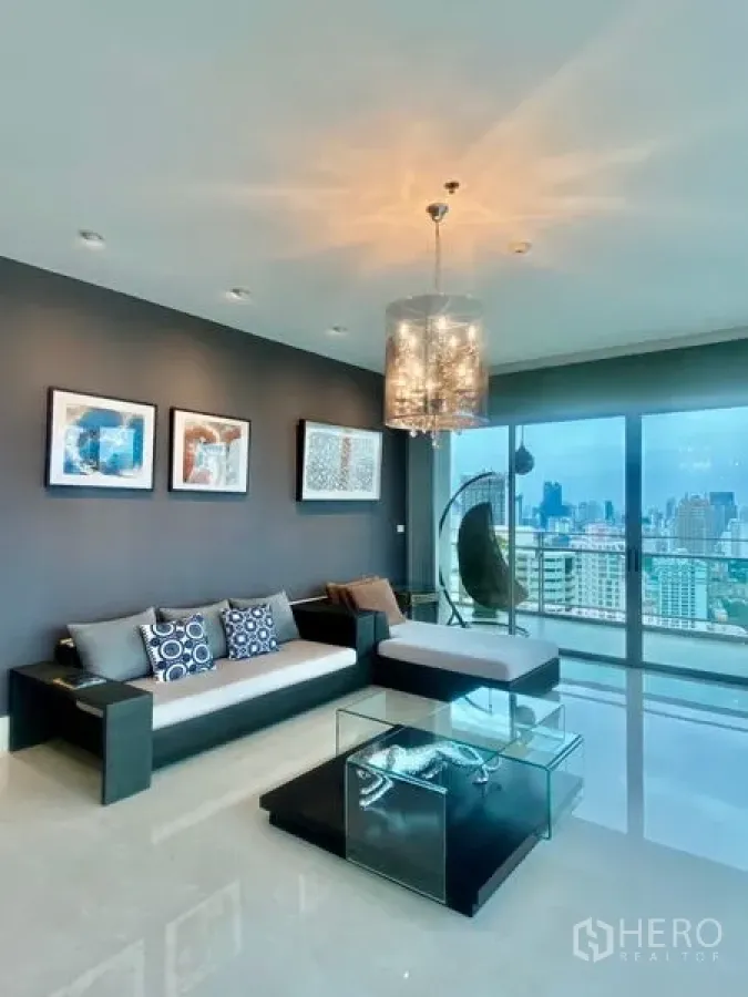 公寓 出租在Watthana, Bangkok - 现代客厅，水晶吊灯与玻璃茶几，落地窗连通观景阳台俯瞰城市。