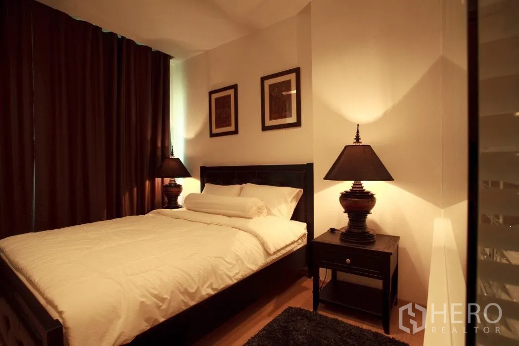 Condominium for rent in Khlong Toei, Bangkok - Primary bedroom with queen bed, matching nightstands and soft ambient lighting.