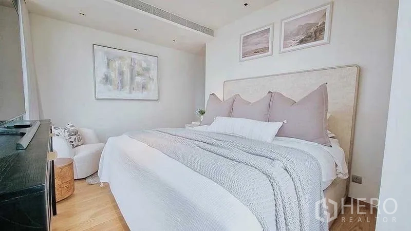 Condominium for sale - Bright bedroom featuring upholstered bed, soft bedding and minimalist artwork.