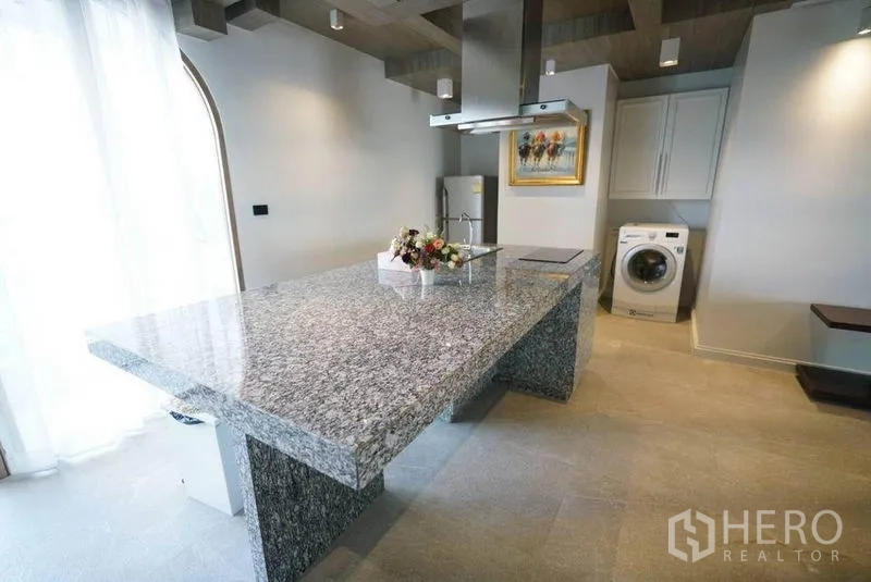 Condominium for rent or sale in Bang Na, Bangkok - Open kitchen featuring a large granite island, range hood, fridge and washing machine.