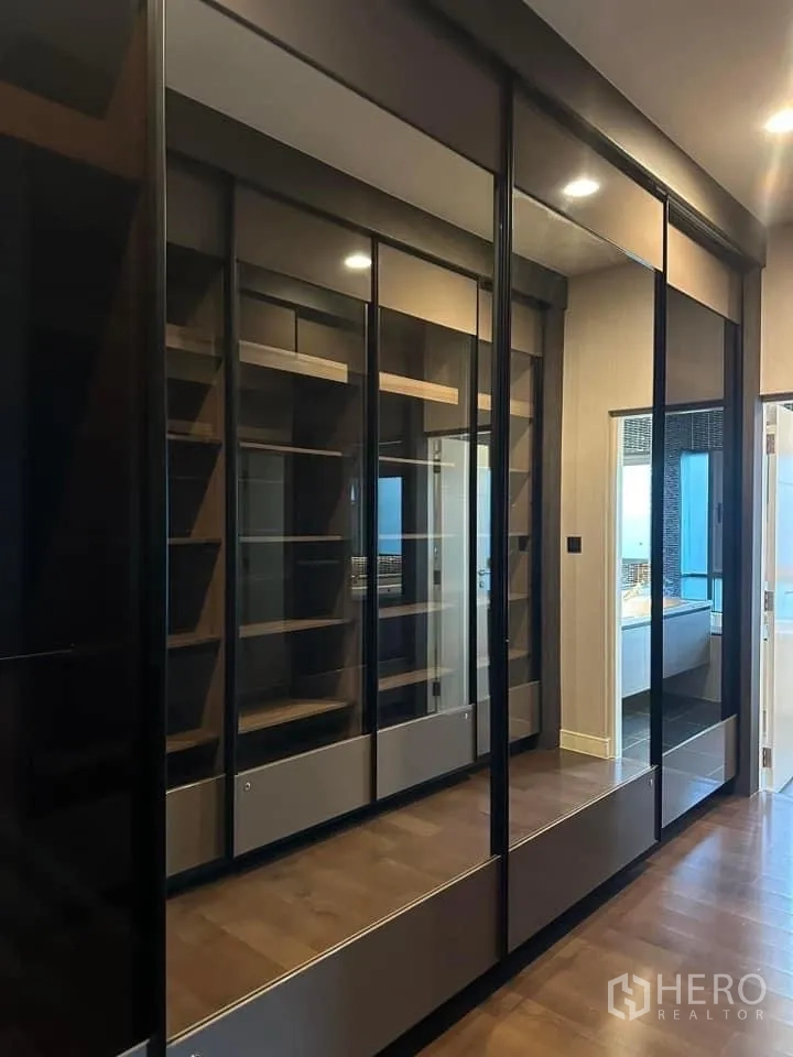 Detached House for rent in Bang Kapi, Bangkok - Walk-in closet fitted with glass-front wardrobes and open shelving.