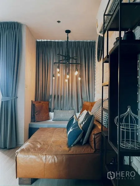 Condominium for rent in Suan Luang, Bangkok - Cozy seating nook with chandelier lighting and floor-to-ceiling curtains