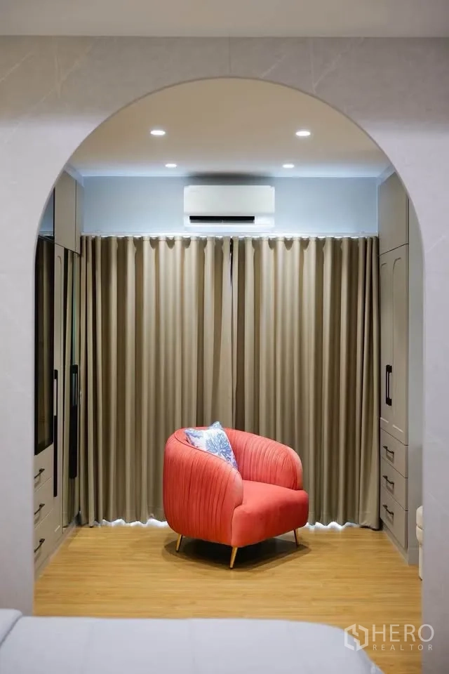 บ้านเดี่ยว for sale in Bang Phli, Samut Prakan - มุมนั่งเล่นผ่านซุ้มโค้งมีเก้าอี้สีชมพูและผ้าม่านทึบ.