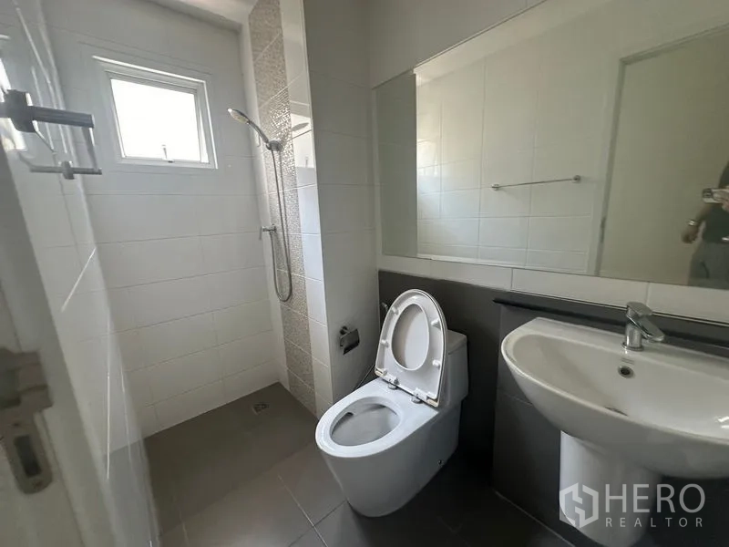 Home Office for rent in Bang Na, Bangkok - Clean bathroom with walk-in shower, toilet, sink and a wide mirror.