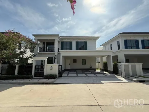 独立式住宅 出租或出售在Bang Phli, Samut Prakan - 晴天社区街景下的房屋正面视角。