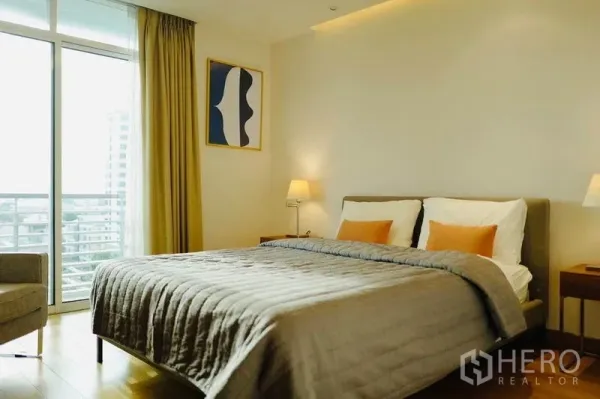 Condominium for rent or sale in Phaya Thai, Bangkok - Bright bedroom with double bed, bedside lamps and balcony access overlooking Bangkok.