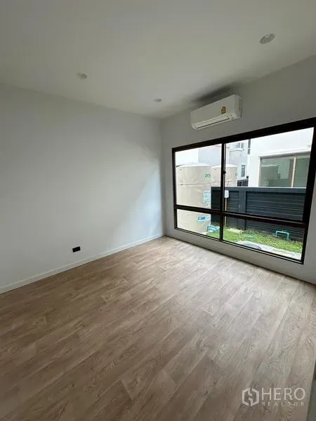 独立式住宅 出租在Bang Kapi, Bangkok - 采光充足的卧室，木纹地板，大窗与壁挂空调。