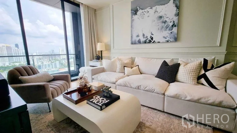 Condominium for sale - Living room with oversized sofa, armchair and balcony overlooking the city.