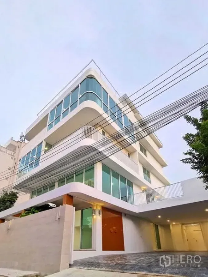 带办公室的家 出售在Suan Luang, Bangkok - 白天转角外观，圆角玻璃与车道入口