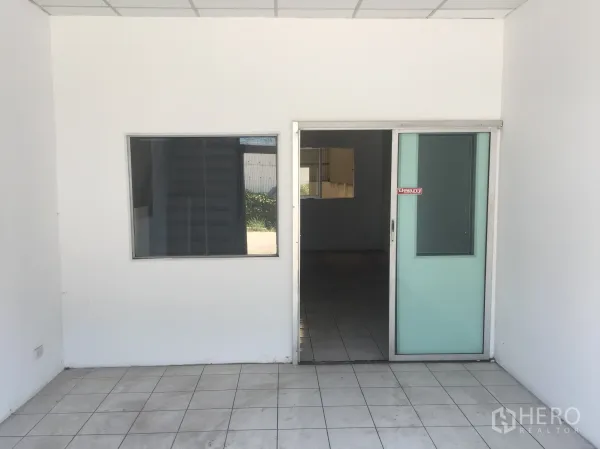 Factory for rent in Khlong Luang, Pathum Thani - Ground-floor office entrance with a sliding glass door and tiled floor.