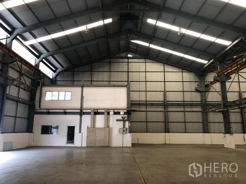 Factory for rent in Khlong Luang, Pathum Thani - Warehouse wall with attached mezzanine office and electrical panels.