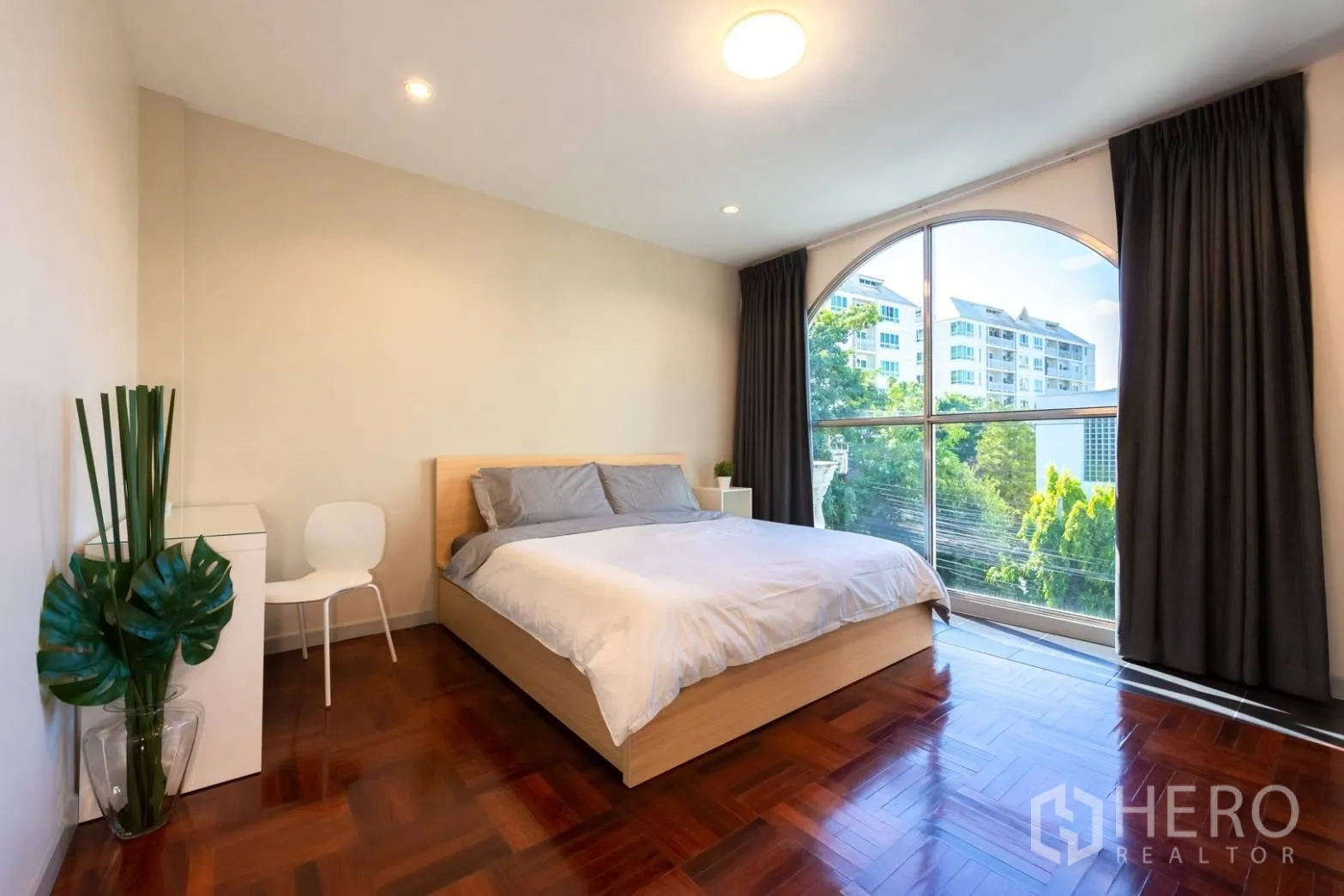 Home Office for rent in Bang Rak, Bangkok - Bedroom with large arched window, garden outlook and polished wood flooring.