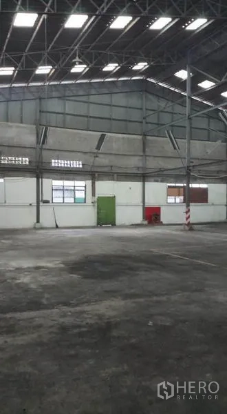 Warehouse for rent in Bang Phli, Samut Prakan - Wide interior area with windows and wall vents along the side.