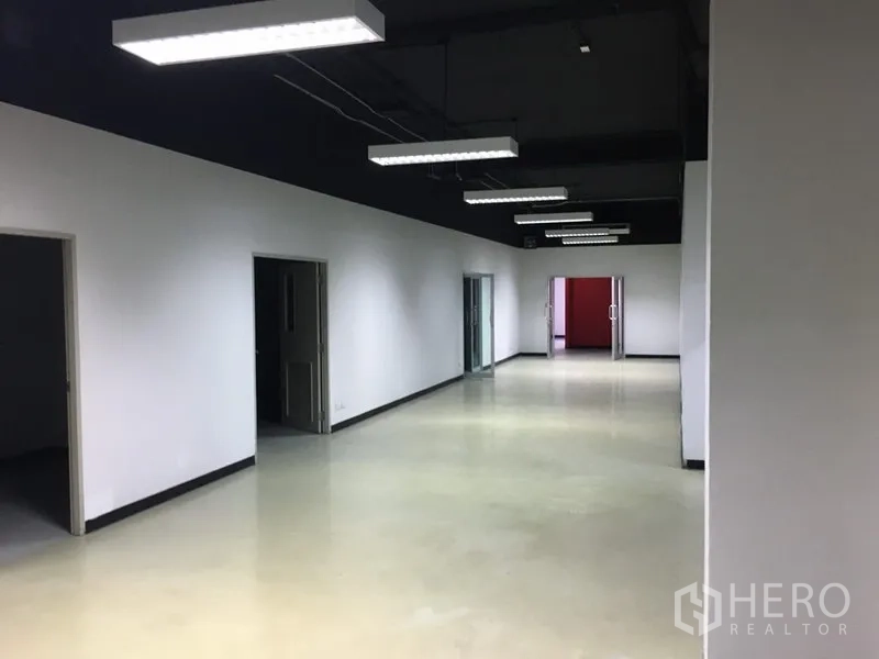 สำนักงาน ให้เช่าในHuai Khwang, Bangkok - โถงทางเดินกว้าง มีห้องทำงานหลายห้องและประตูกระจก ใต้ไฟแขวน