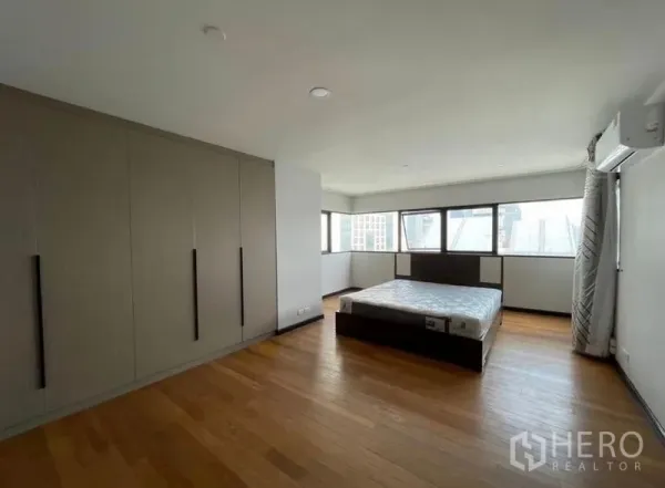 Condominium for rent - Primary bedroom with large built-in wardrobes, hardwood floors and panoramic windows.