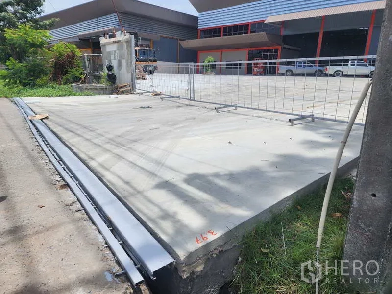 Factory for rent in Chachoengsao - Newly poured concrete entrance ramp and sliding gate area leading into the factory compound.
