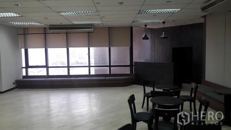 Office Space for rent in Huai Khwang, Bangkok - Corner lounge area featuring floor-to-ceiling windows, roller blinds and bench seating.