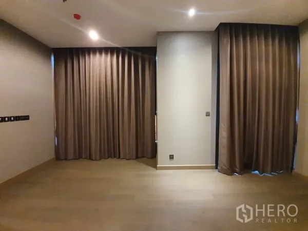 คอนโด ให้เช่าในHuai Khwang, Bangkok - พื้นที่นั่งเล่นกว้าง พื้นไม้ ไฟดาวน์ไลท์ และม่านทึบเต็มความสูง