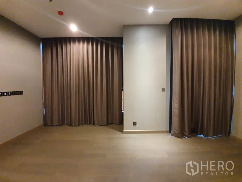 คอนโด ให้เช่าในHuai Khwang, Bangkok - พื้นที่นั่งเล่นกว้าง พื้นไม้ ไฟดาวน์ไลท์ และม่านทึบเต็มความสูง