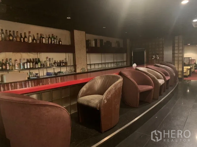 Retail Space for rent in Bang Rak, Bangkok - Long red-topped bar counter with bottle shelving and plush club chairs.