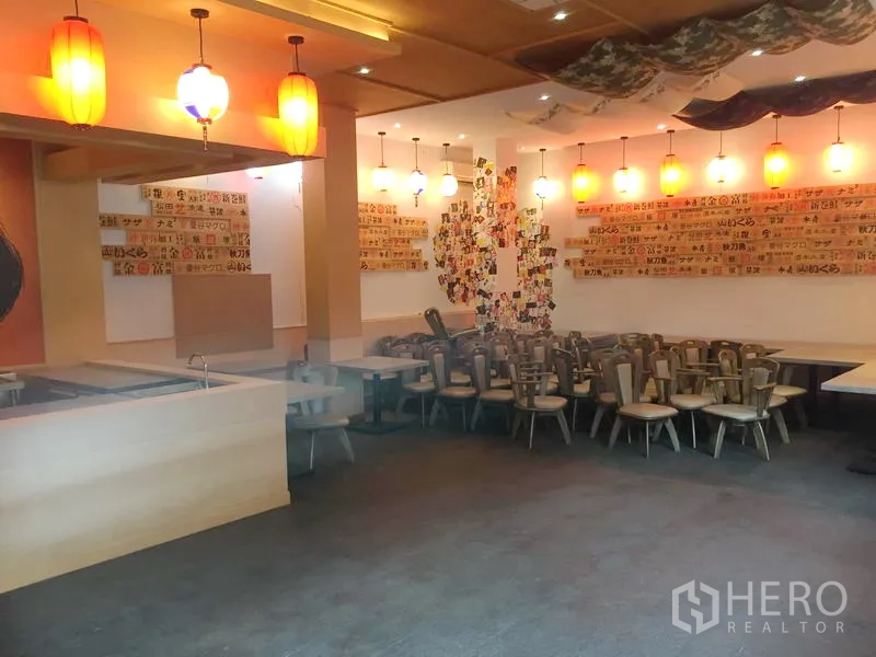 Retail Space for rent in Khlong Toei, Bangkok - Spacious dining area featuring pendant lights, wall menu panels and stacked chairs ready for setup.