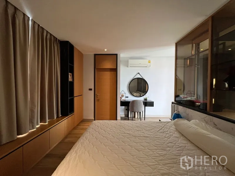 Townhouse for rent in Saphan Sung, Bangkok - Bedroom with writing desk, wall-mounted air-con, and large bed.