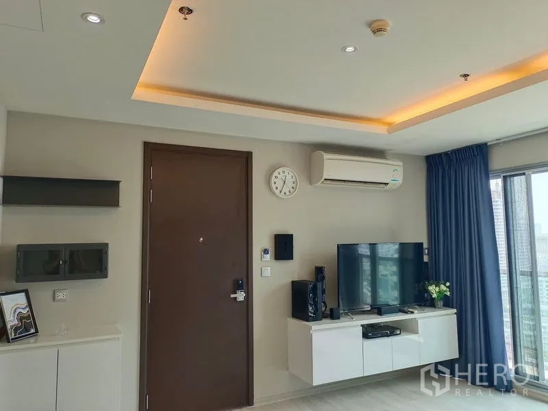 Condominium for rent in Watthana, Bangkok - Entry wall with mounted TV, air conditioner and recessed ceiling lighting.