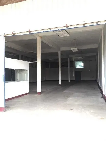 Warehouse for rent in Bueng Kum, Bangkok - Wide warehouse entrance with large opening and internal office unit, smooth concrete flooring.