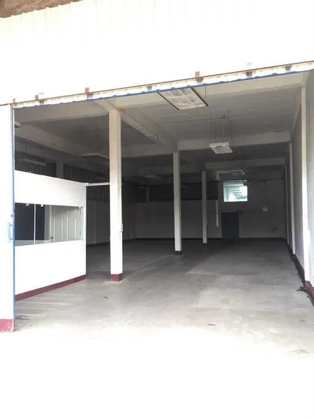 Warehouse for rent in Bueng Kum, Bangkok - Wide warehouse entrance with large opening and internal office unit, smooth concrete flooring.