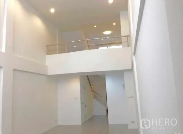 带办公室的家 出租在Wang Thonglang, Bangkok - 室内挑高大堂，白色墙面带夹层与嵌入式照明，连接楼梯。