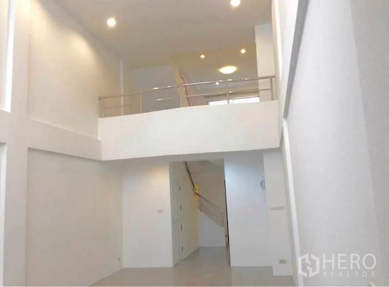 带办公室的家 出租在Wang Thonglang, Bangkok - 室内挑高大堂，白色墙面带夹层与嵌入式照明，连接楼梯。