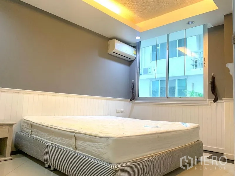 Condominium for rent in Khlong Toei, Bangkok - Bright bedroom with large window, air conditioner and cove lighting at Waterford Sukhumvit 50 near BTS On Nut.