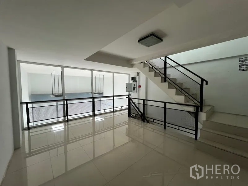 货栈 出租在Bang Phli, Samut Prakan - 楼梯平台，玻璃墙俯视挑高空间。