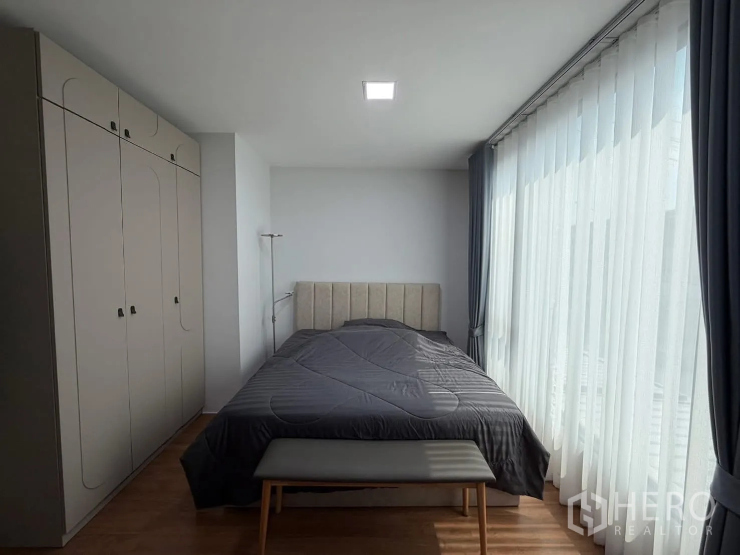 联排别墅 for rent in Bang Phli, Samut Prakan - 主卧配整面落地窗与纱帘，软包床头与长凳，收纳充足。
