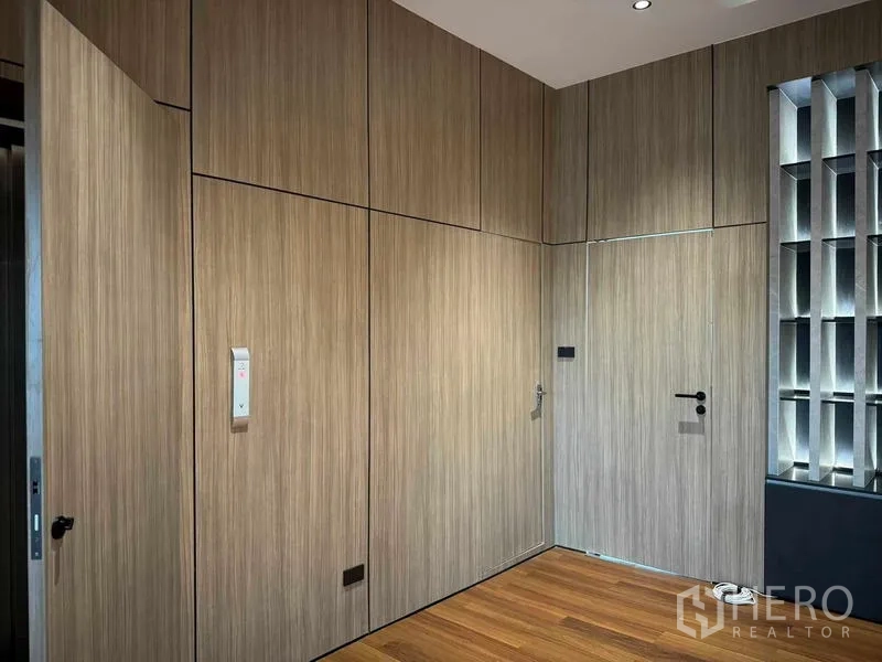 Home Office for rent or sale in Bang Phli, Samut Prakan - Close‑up of wood wall panels with concealed doors and a lift control.