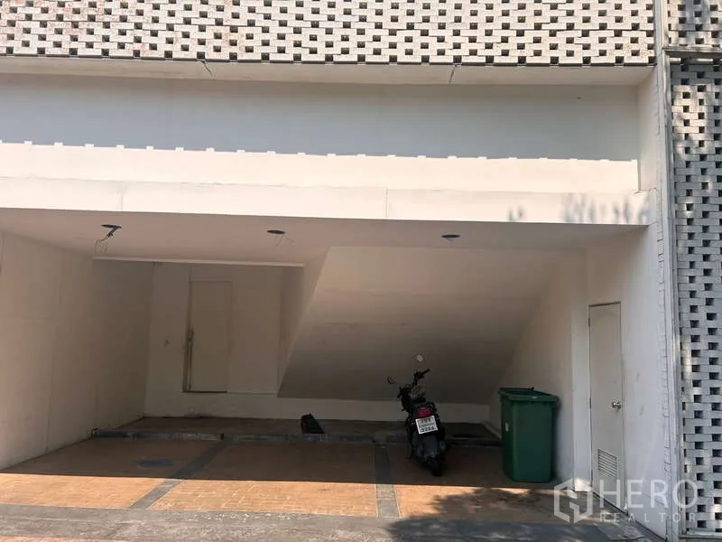 Standalone for rent in Khlong Toei, Bangkok - Covered parking bay under the building with lighting and space for vehicles.