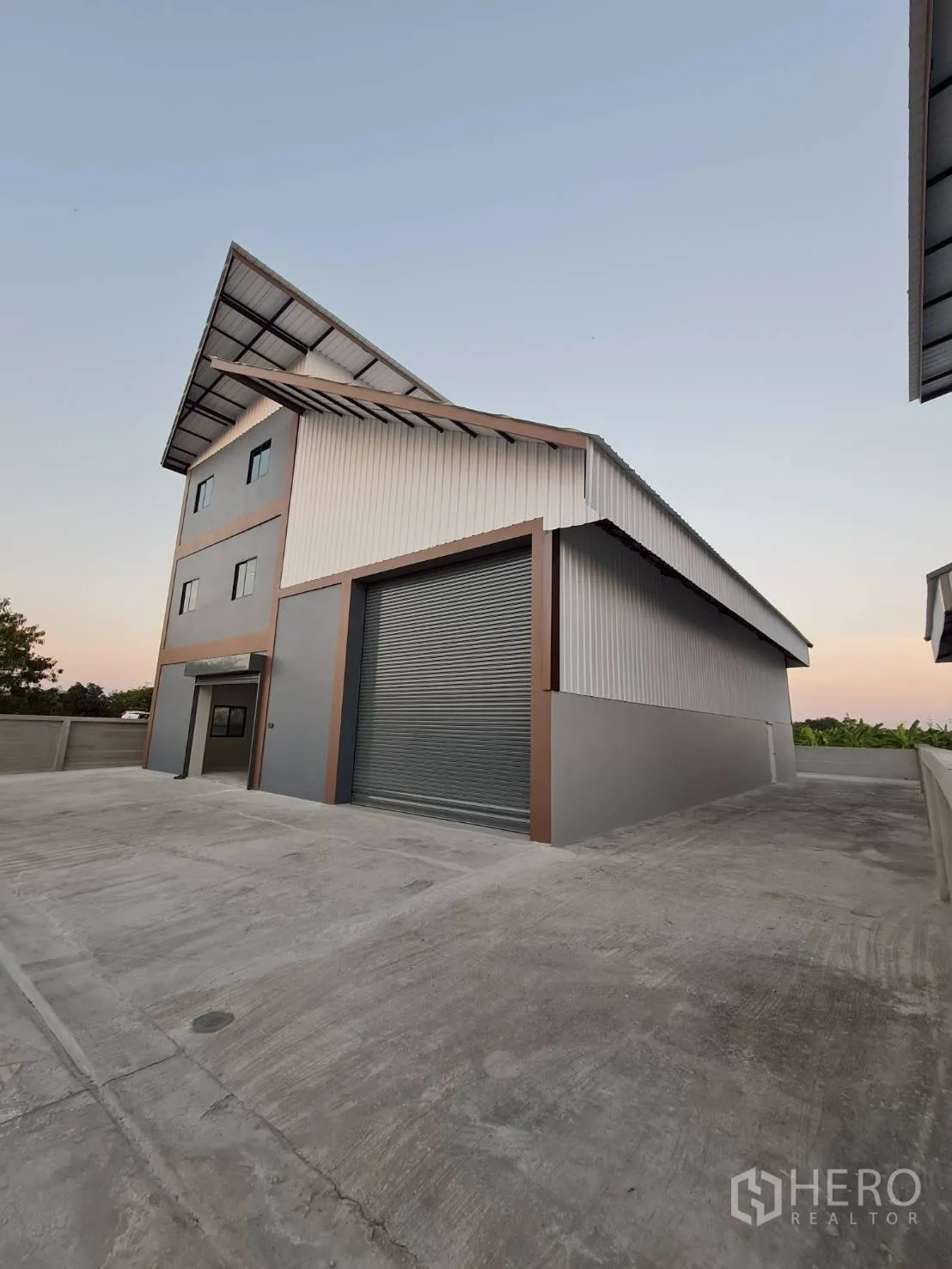 Warehouse for rent in Mueang Nonthaburi, Nonthaburi - Warehouse exterior with closed roller door and wide concrete apron.