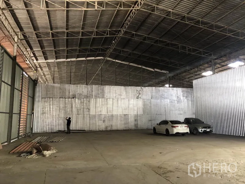 货栈 出租在Nong Chok, Bangkok - 仓库开放式车间，金属板墙体、混凝土地面，屋内可停放车辆。