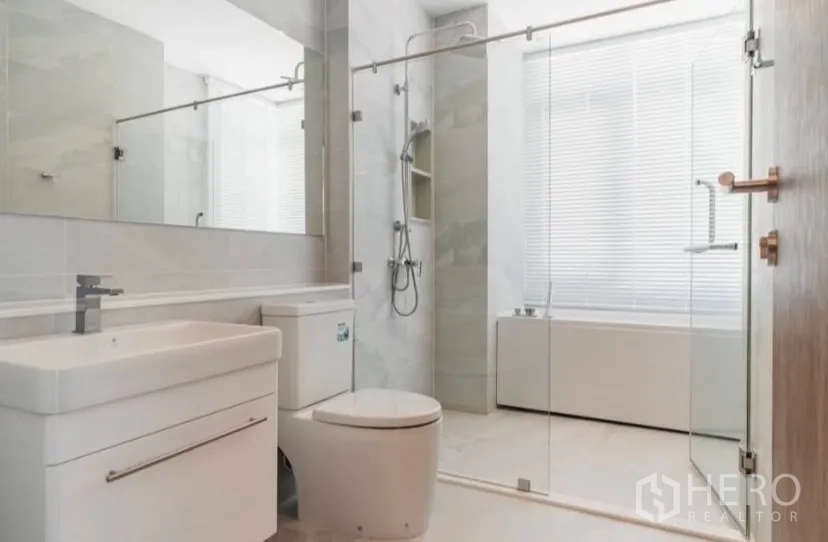 Condominium for rent in Watthana, Bangkok - Bright bathroom with glass shower, bathtub and modern vanity.