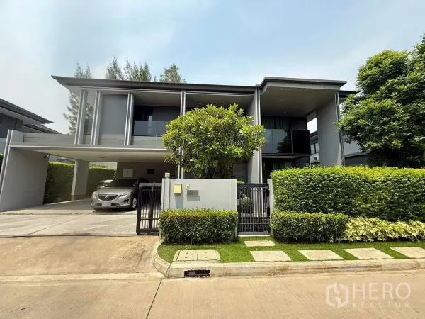 บ้าน ให้เช่าในBang Kapi, Bangkok - บ้านเดี่ยวสองชั้นสไตล์โมเดิร์น พร้อมประตูรั้ว พุ่มไม้ และที่จอดรถในร่ม 3 คัน