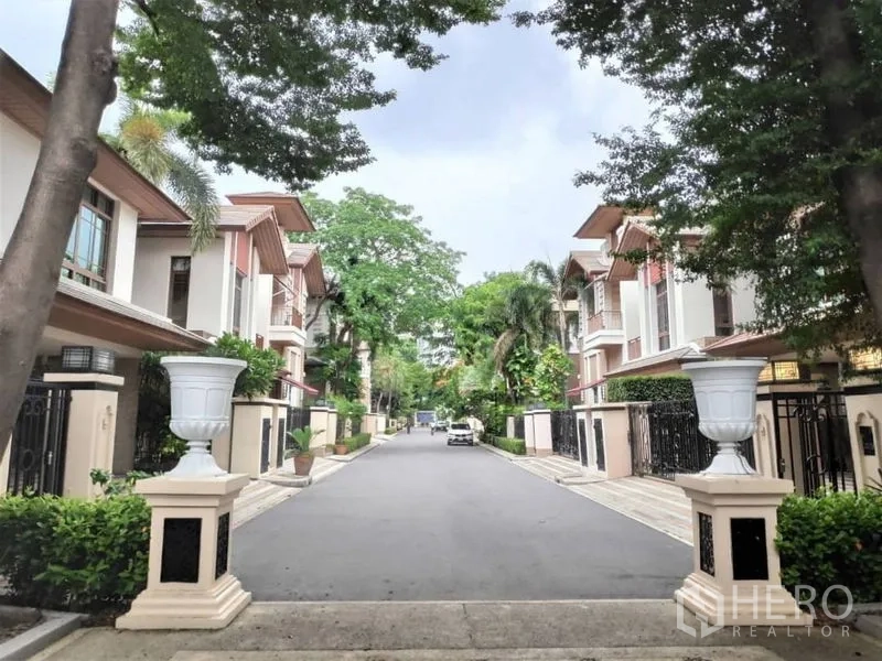 独立式住宅 出租在Watthana, Bangkok - 安静的封闭式社区道路，两侧为现代独栋住宅与成树。