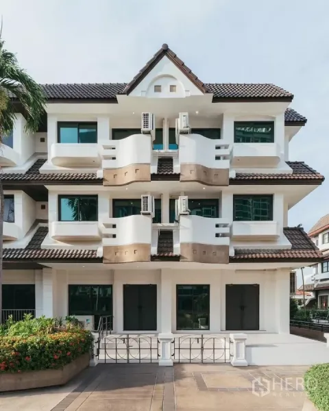 Townhouse for rent in Watthana, Bangkok - Three-storey modern townhouse facade with balconies and tiled roof in Watthana, Bangkok.