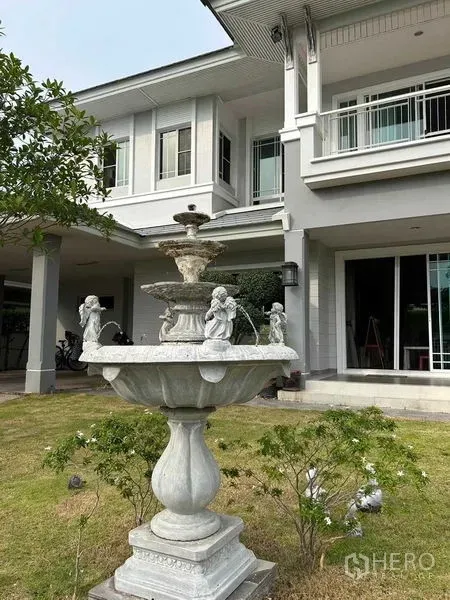 บ้าน ขายในSamut Prakan - สวนหน้าบ้านโดดเด่นด้วยน้ำพุหินแบบคลาสสิก ข้างตัวบ้านสองชั้น
